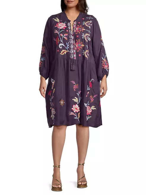 Woman wearing swing silhouette and single-tiered skirt with floral embroidery and tassel accents complete this midi-length look