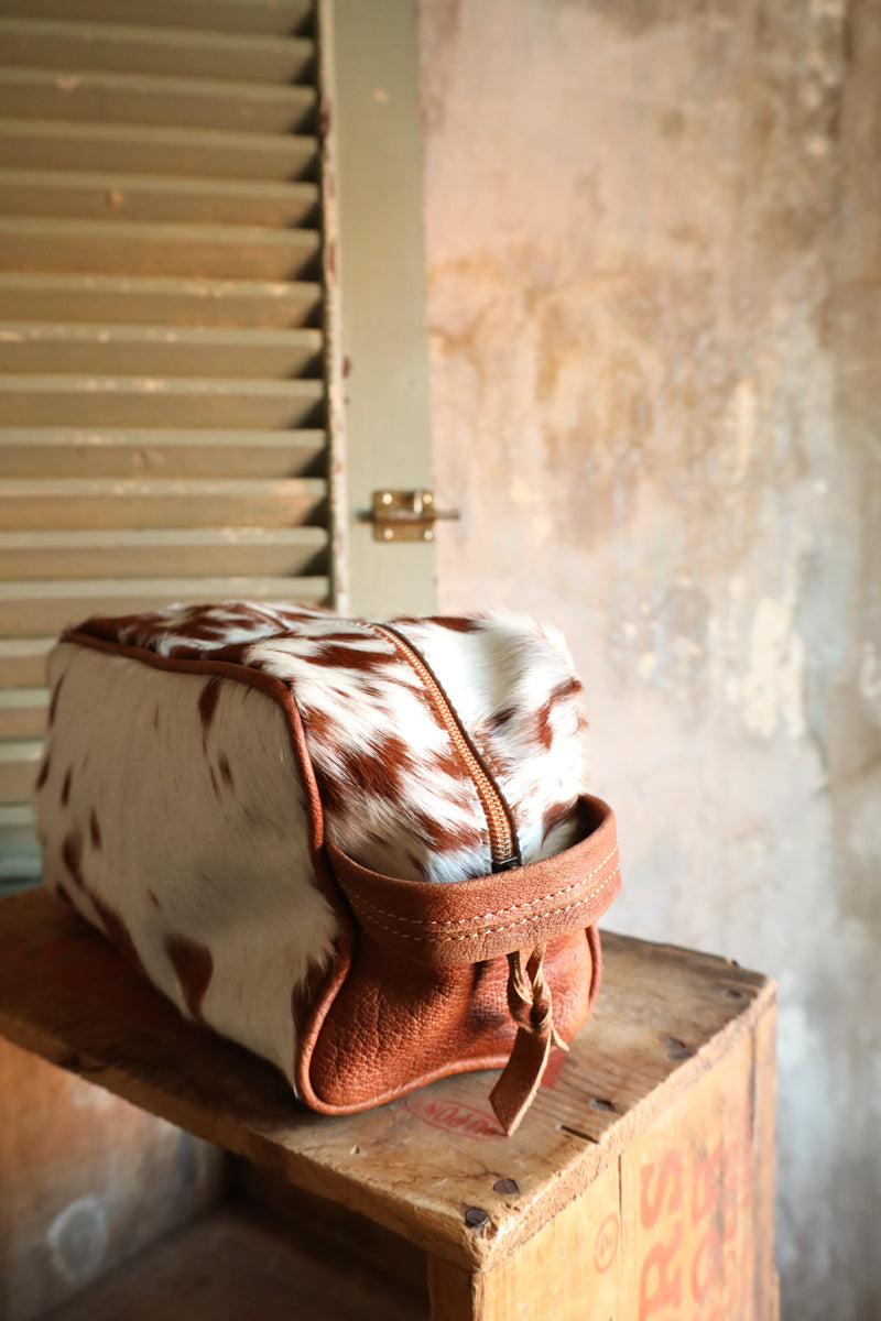 Brown and white cowhide travel kit with zipper closure for easy travel
