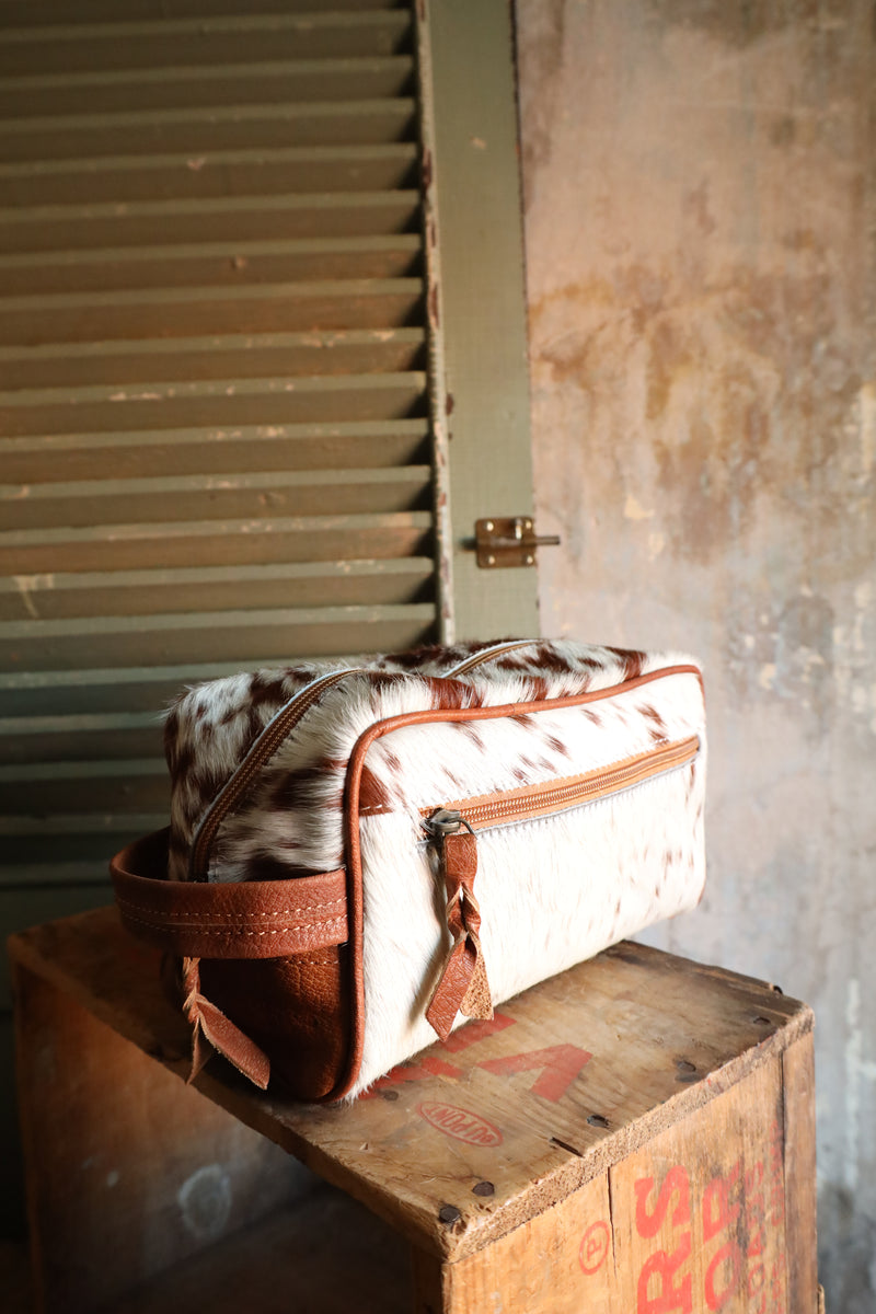Brown and white cowhide travel kit with zipper closure for easy travel