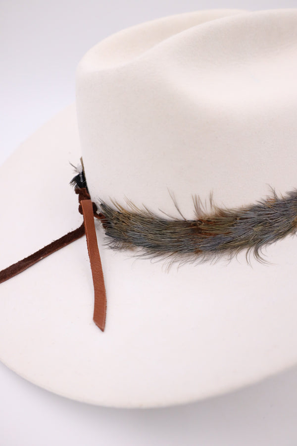Old school western feather hatband with turquoise dot in the center of the feathers