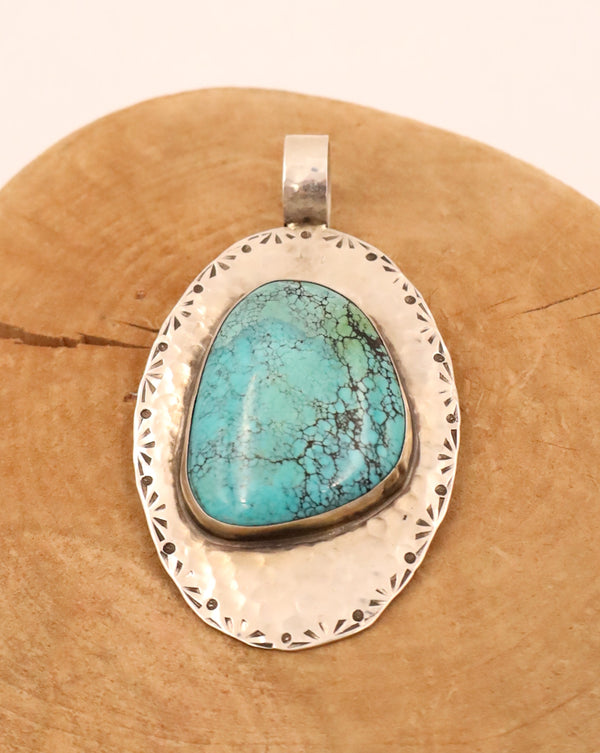 Turquoise gem pendant set in a sterling silver bezel and mounted on a hammered sterling silver oval base