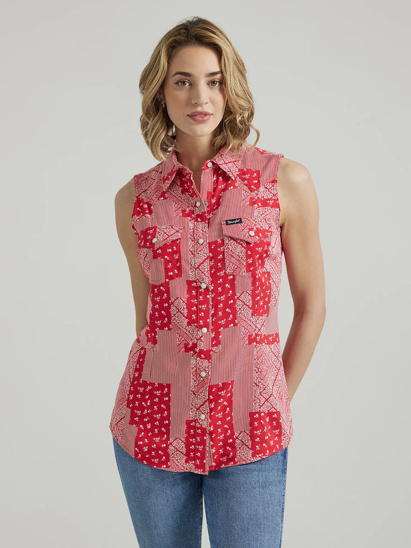 Woman wearing sleeveless pearl snap shirt with patch design with stripes and bandana print 