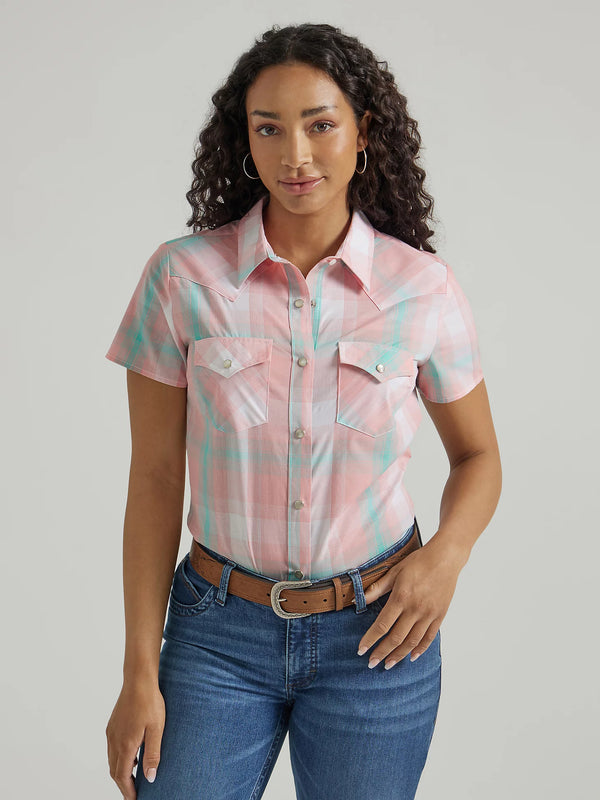 Woman wearing short sleeve pearl snap in a pink and green plaid 