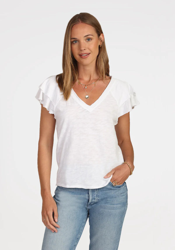Woman wearing white v neck top with ruffle sleeves