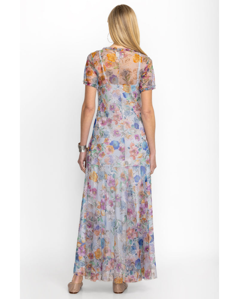 Woman wearing short sleeve maxi mesh dress with multicolor flowers all over and a slip dress underneath