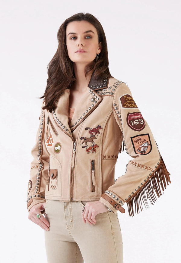 Woman wearing tan suede patch jacket with fringe and studs 