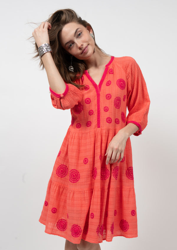 Make a bold statement with Uncle Franks's Many Medallions Dress. This stunning tangerine dress features intricate dark pink embroidery and flowy mid-length sleeves. Perfect for any occasion, this dress will make you stand out and feel confident. Elevate your wardrobe with this unique piece!