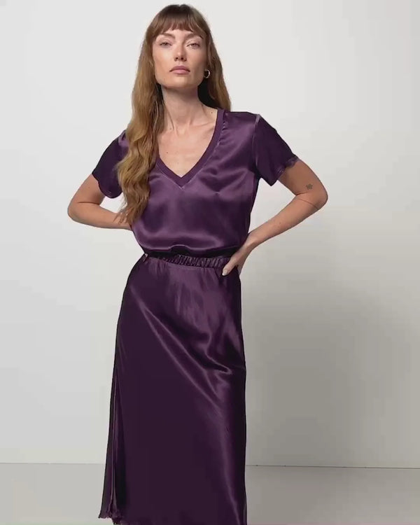 Woman wearing silk, deep purple, v-neck, short sleeve shirt