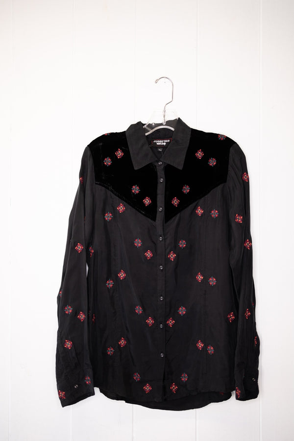 A subtle statement piece, this shirt features a collar, a front button closure, long sleeves, and a dainty red floral pattern