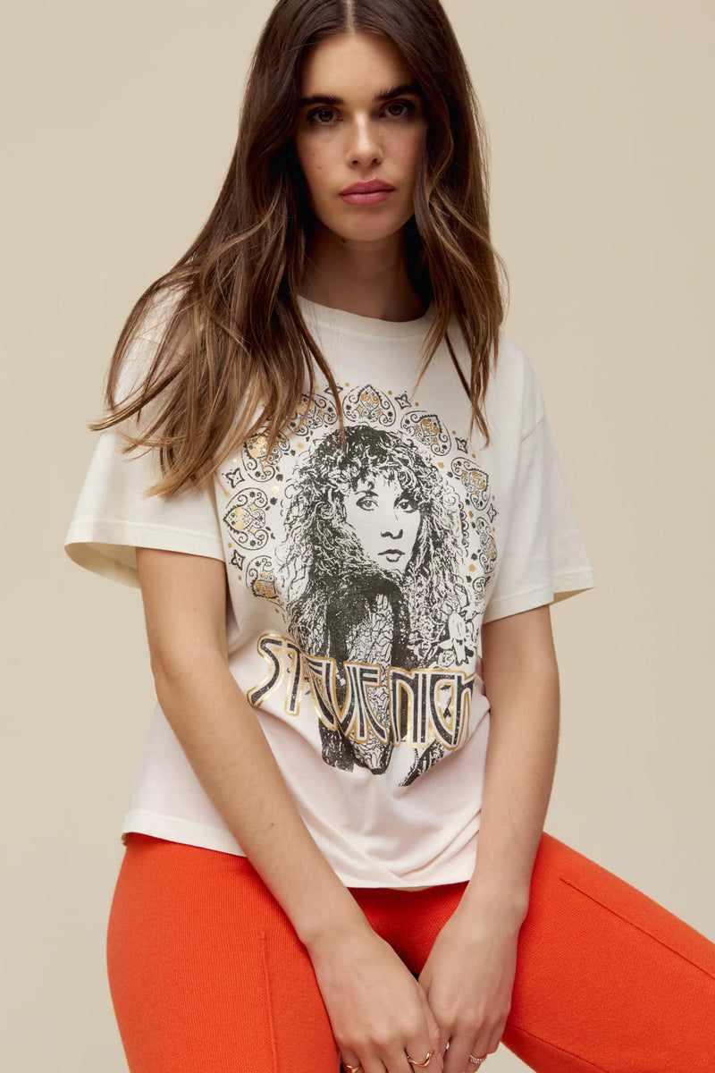 Woman wearing a portrait fit to represent the icon’s free-spirited energy and 70s bohemian style lands center accented in metallic ink t shirt