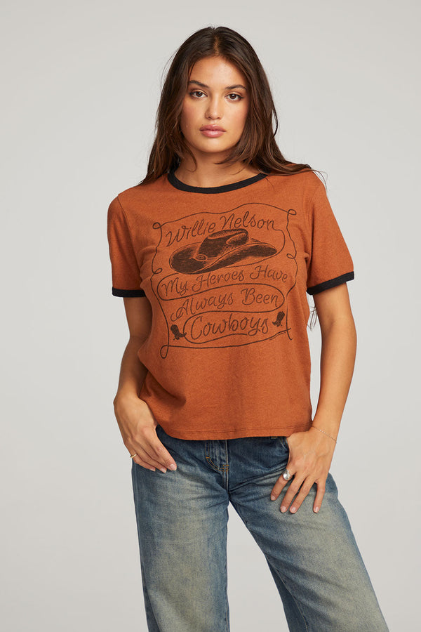 WOMAN WEARING DEEP ORANGE GRAPHIC TEE WITH WORDS "WILLIE NELSON MY HEROES HAVE ALWAYS BEEN COWBOYS"