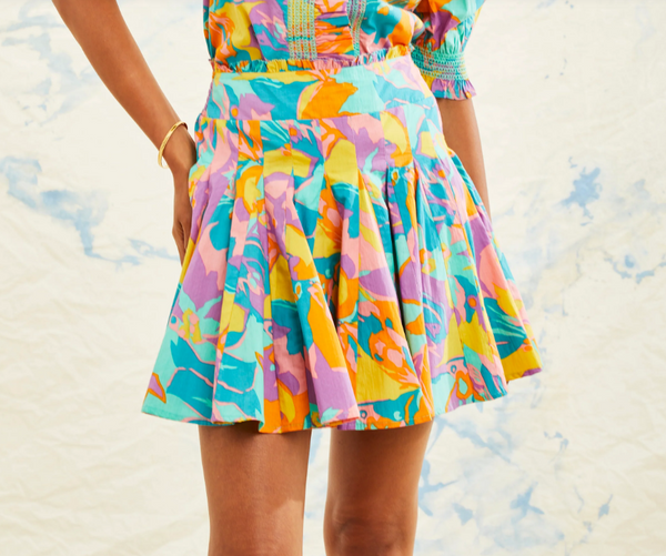 Woman wearing colorful floral pleated skirt