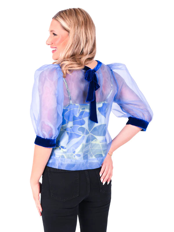 Woman wearing dainty organza along with puff sleeves and velvet trim top