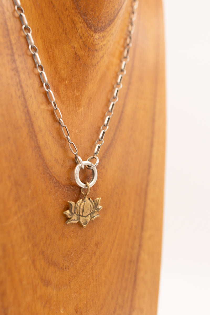 Bronze lotus flower charm on display necklace 