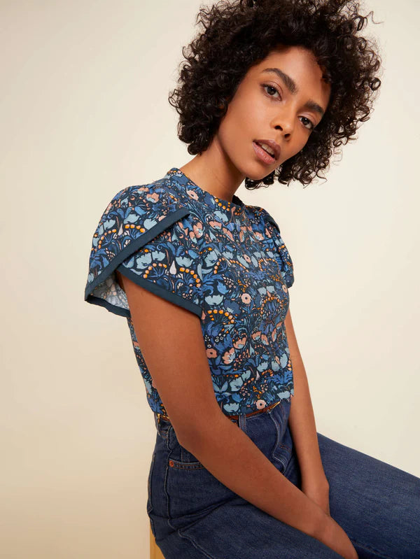 Woman wearing floral print top with puffy short sleeves 