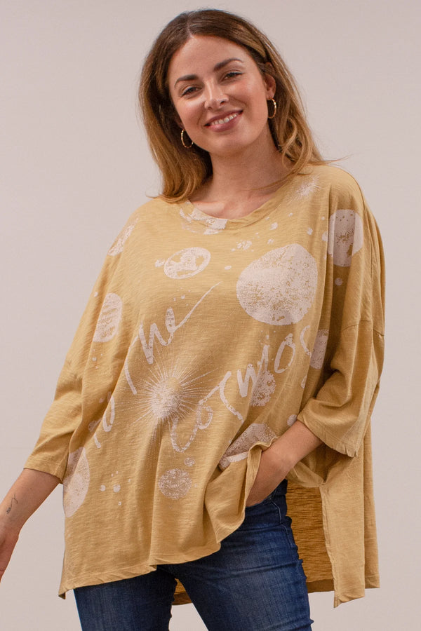 Yellow oversize top with elbow length top with side slits and planets with words "to the cosmos" printed on it.