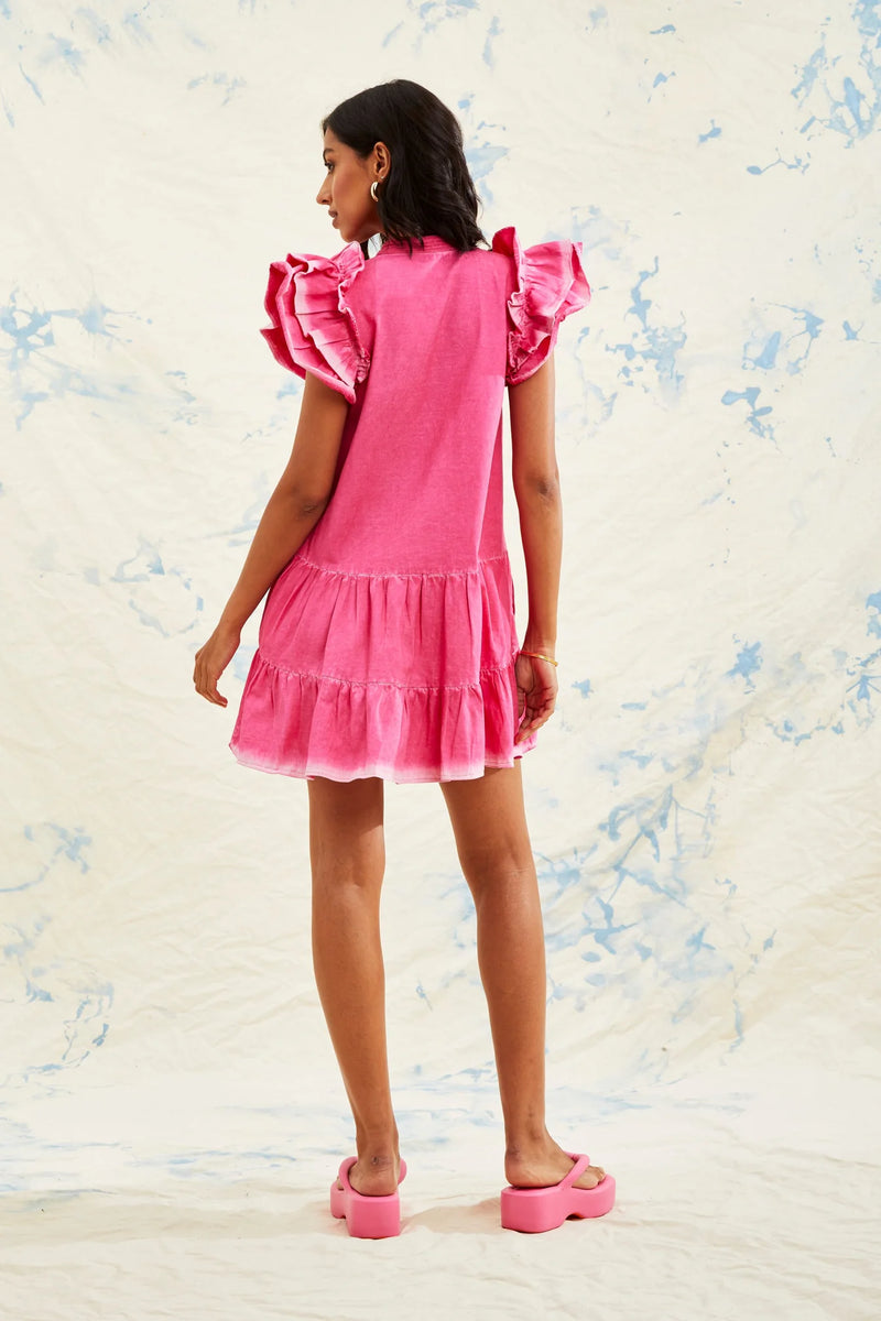 WOMAN WEARING PINK TIERED DRESS WITH RUFFLE SLEEVES