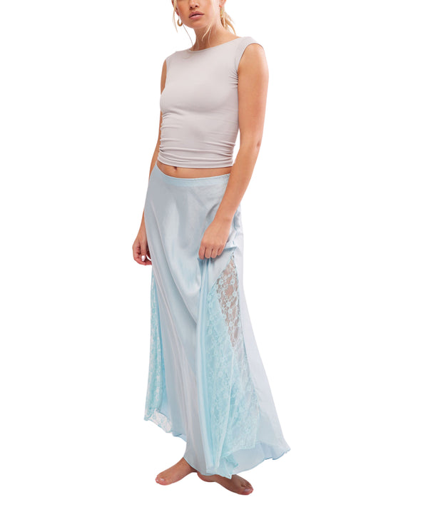 Woman wearing slinky skirt is featured in a satiny fabrication and mid-rise fit with delicate lace detailing and subtle pleating for added dimension