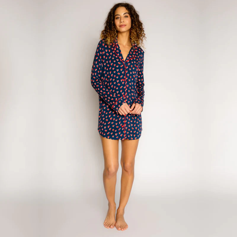 Woman wearing sleepshirt with navy background and red hearts