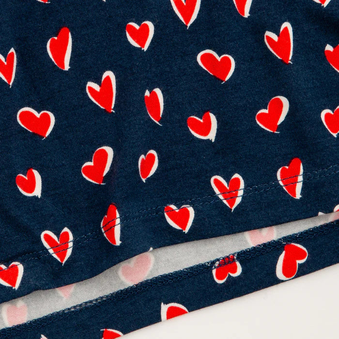 Woman wearing sleepshirt with navy background and red hearts