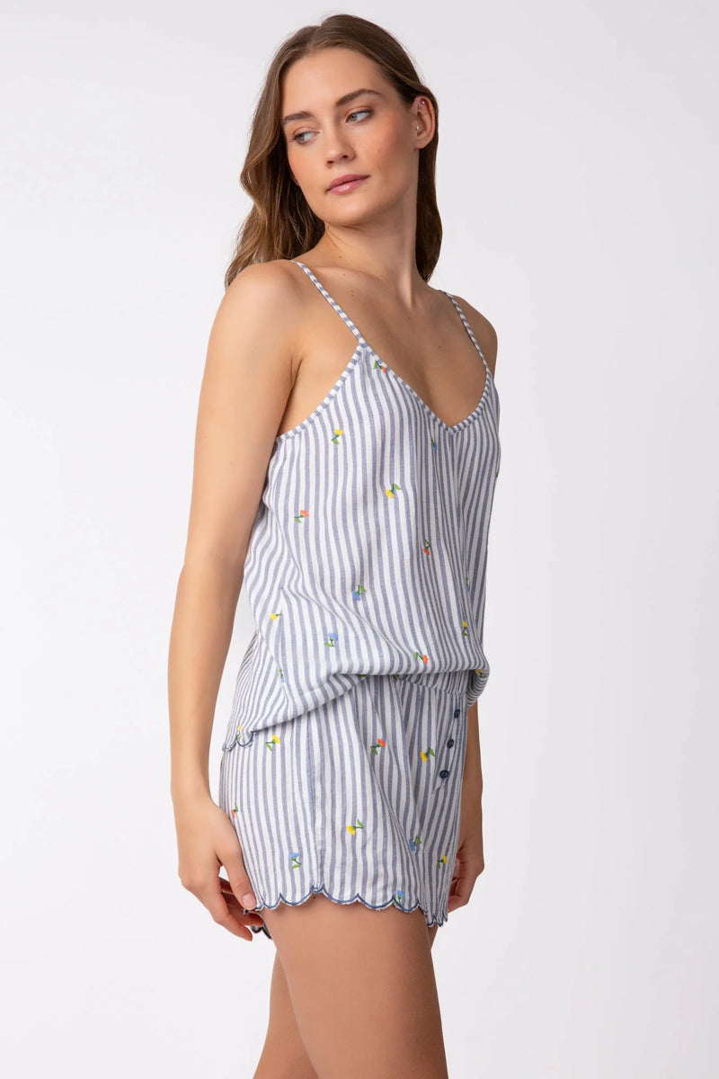 Woman wearing denim grey and white stripe cami with embroidered flowers all over with scallop hem detail