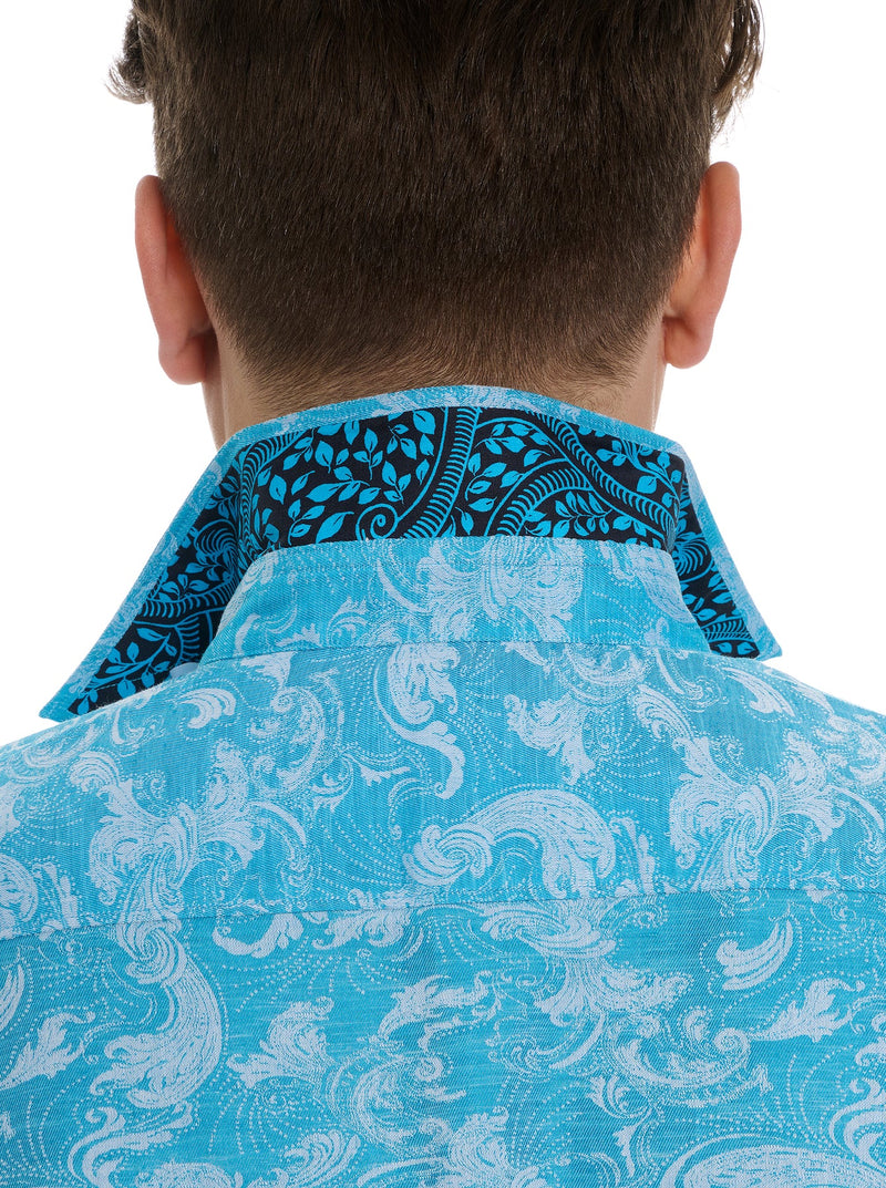 Man wearing shirt sleeve button down shirt with ornate detail in a monochromatic turquoise