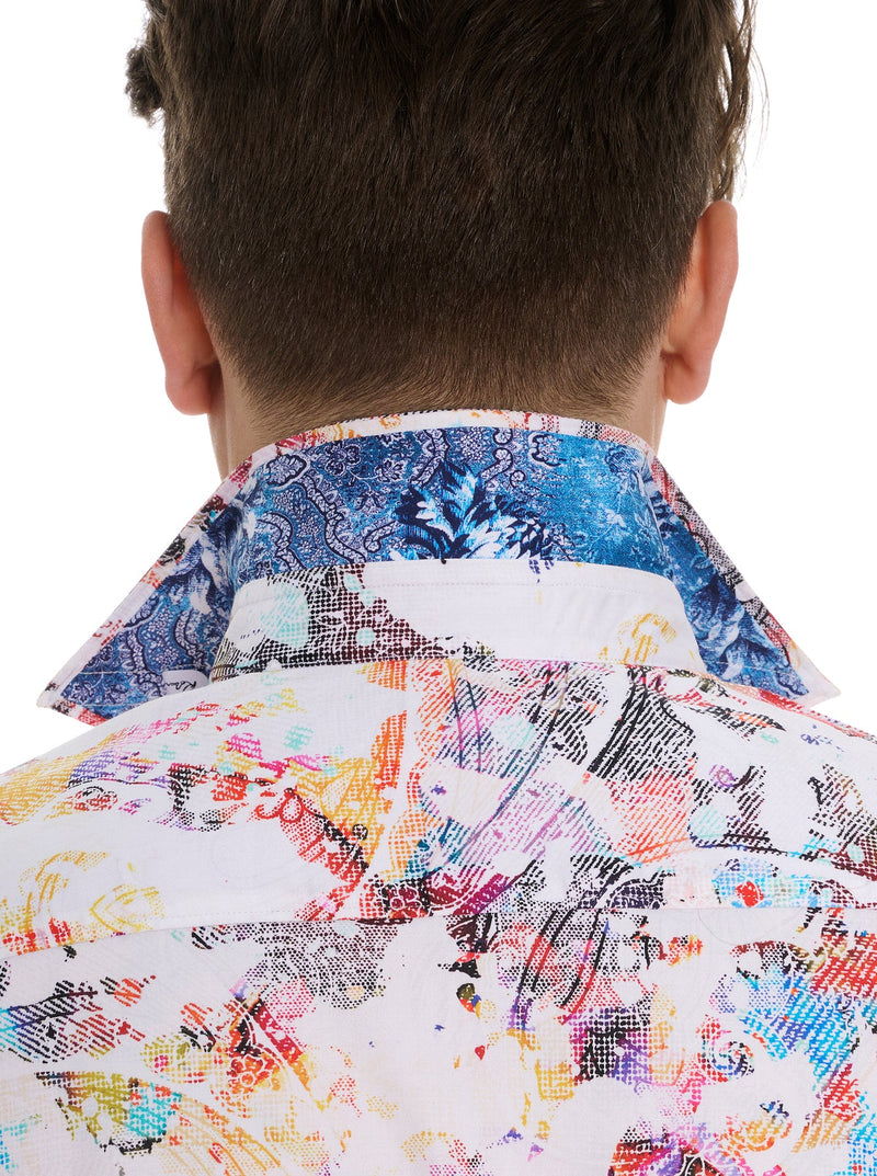 Man wearing multi color short sleeve shirt with antique images of paisley and floral pattern and button front