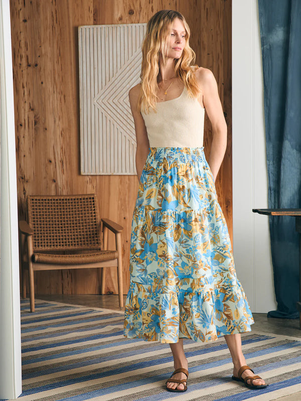 Woman wearing midi skirt in blue, yellow and khaki floral print 