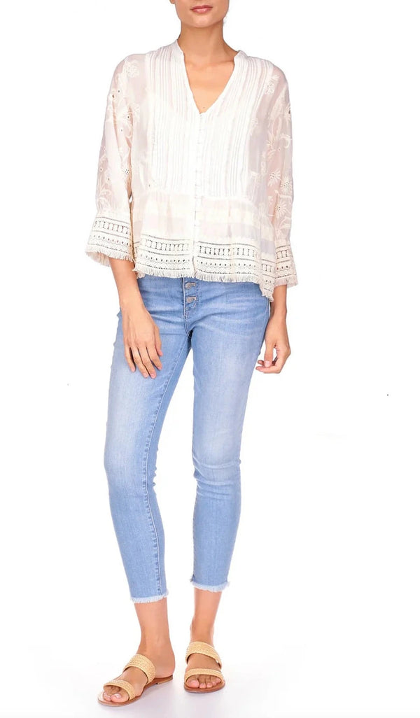 Woman wearing white floral blouse with lace detailing at the hem