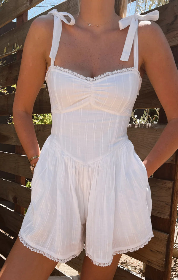 White romper with adjustable straps that form into bows on the shoulders
