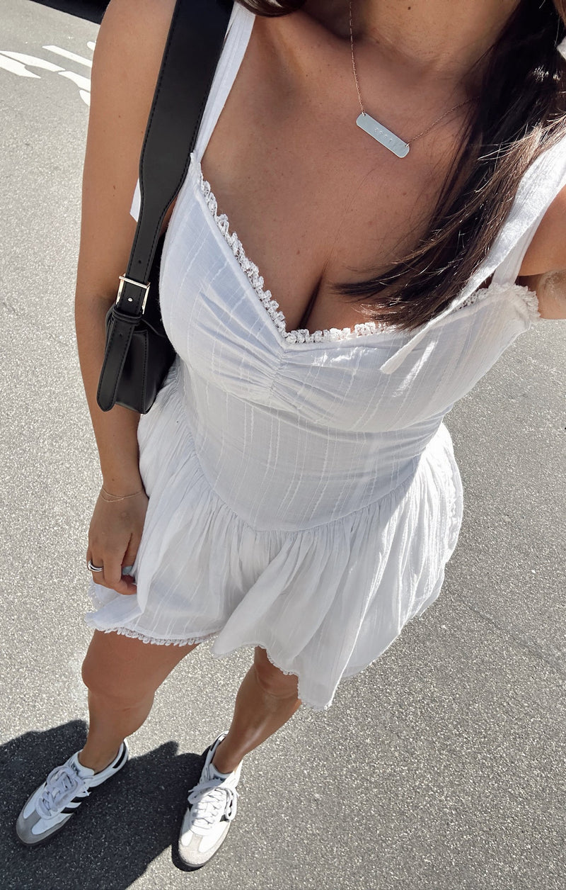 White romper with adjustable straps that form into bows on the shoulders