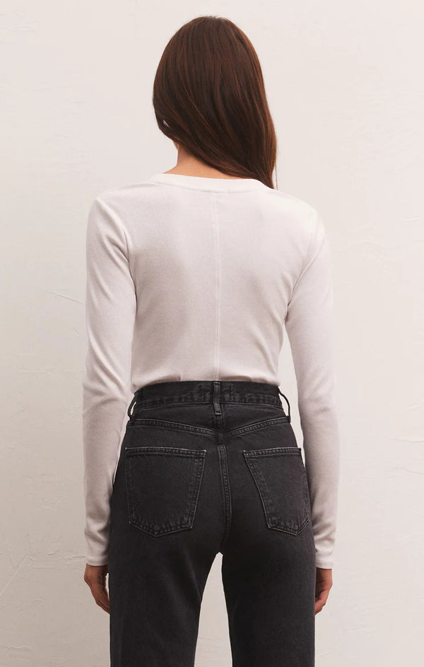 Woman wearing ribbed long sleeve scoop neck shirt.