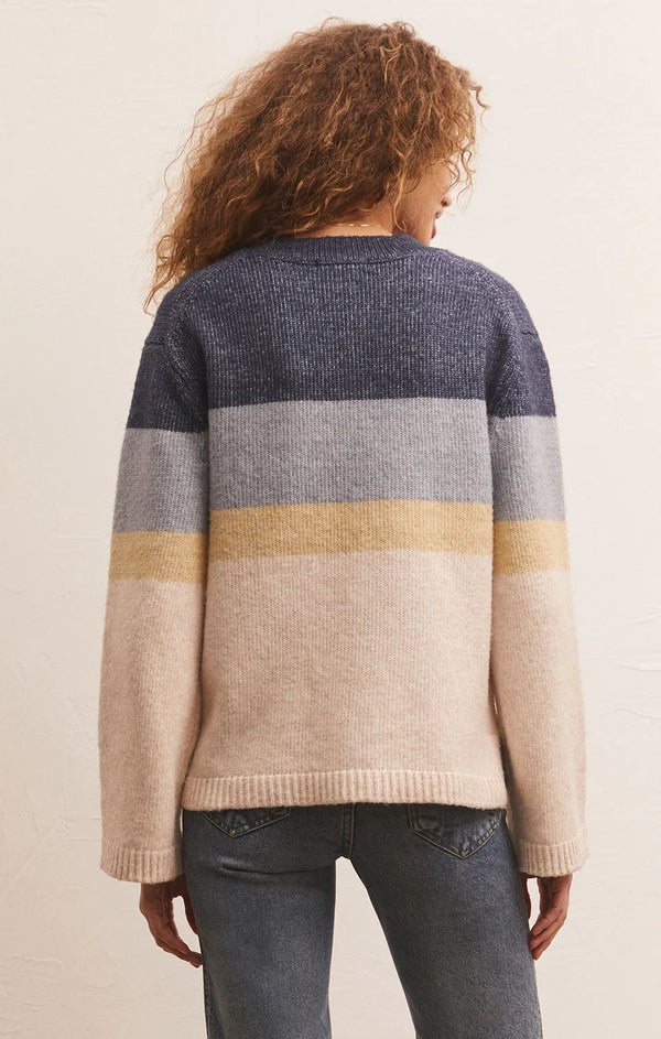 Woman wearing oversized sweater with various color chunky stripes