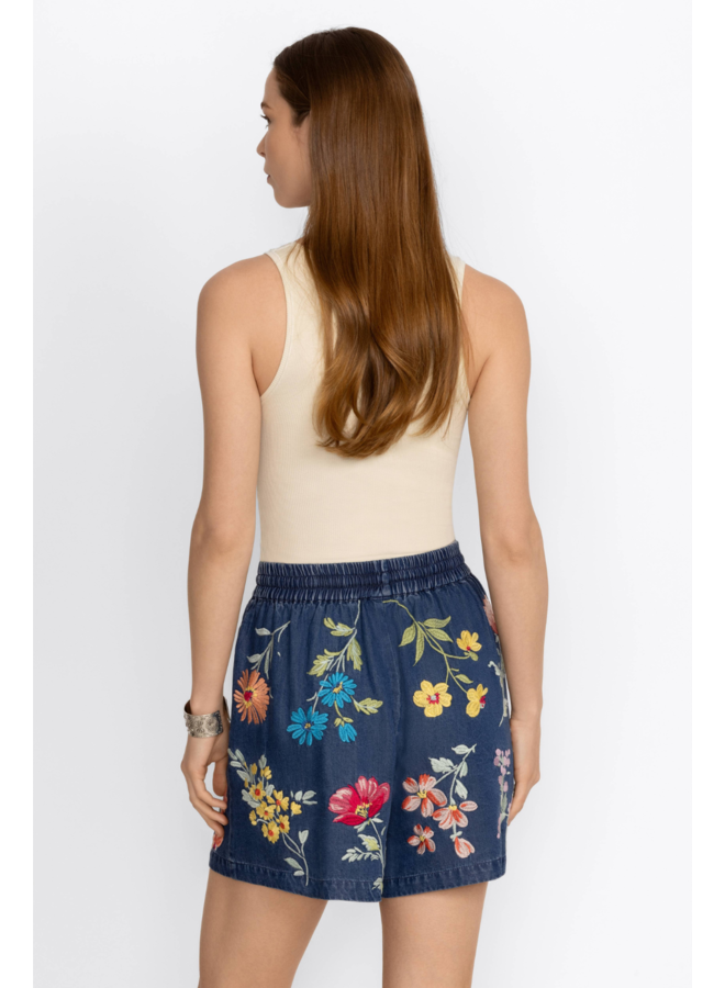 Woman wearing drawstring tinsel shorts with floral embroidery all over