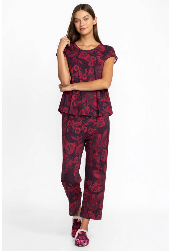 Woman wearing maroon pjs with floral pattern throughout 