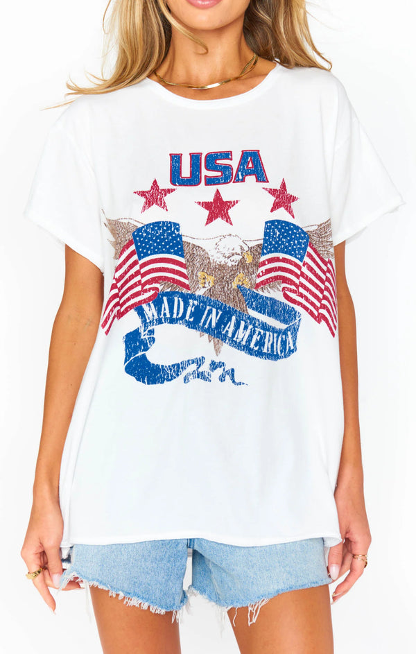 Woman wearing graphic tee with script "USA Made In America" with two American Flags and a bald eagle coming out of the center
