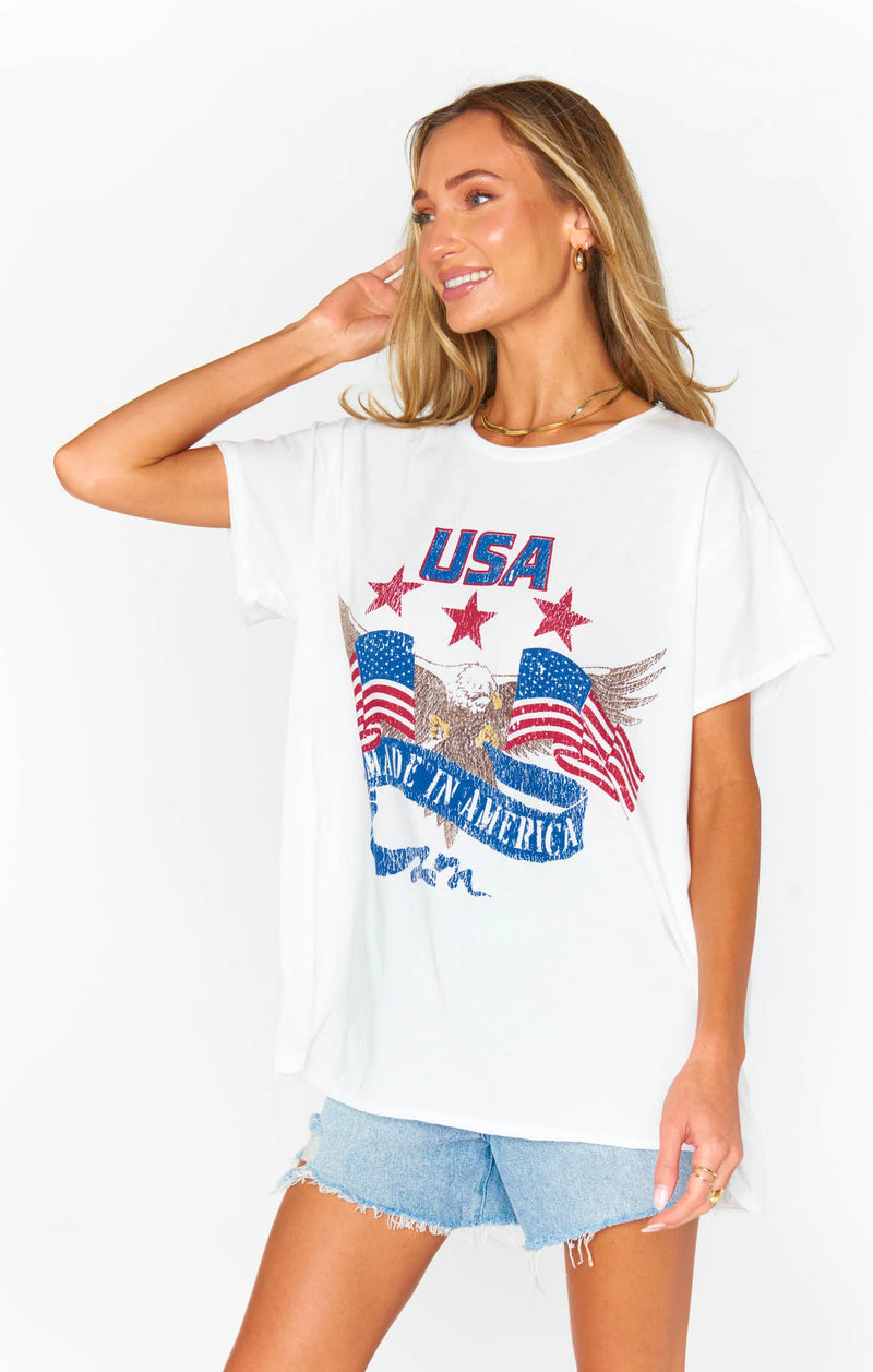 Woman wearing graphic tee with script "USA Made In America" with two American Flags and a bald eagle coming out of the center