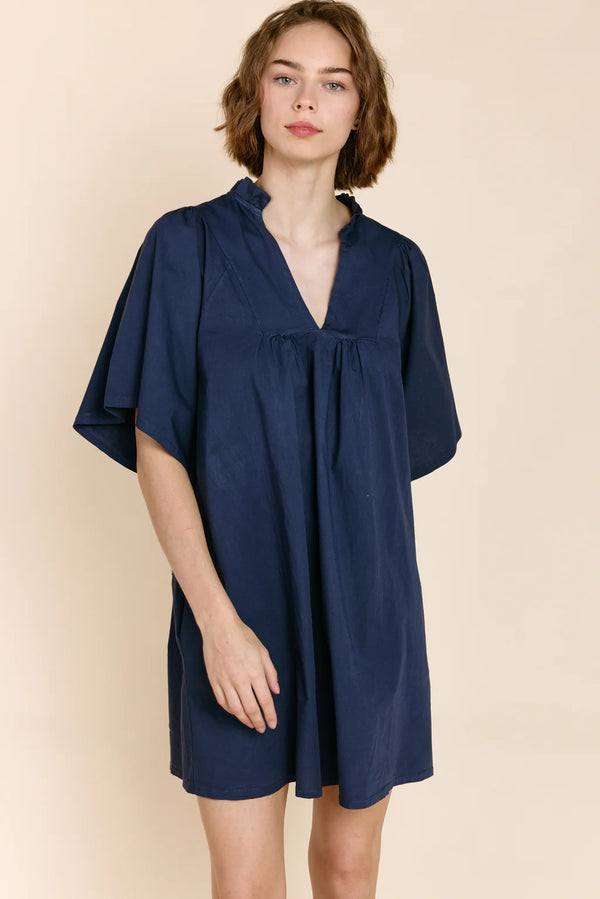 Woman wearing flowy short sleeve dress in navy with v-neck