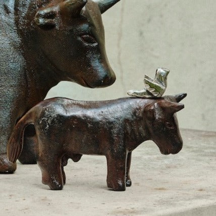 Small sculpture of donkey with bird on the top of its head