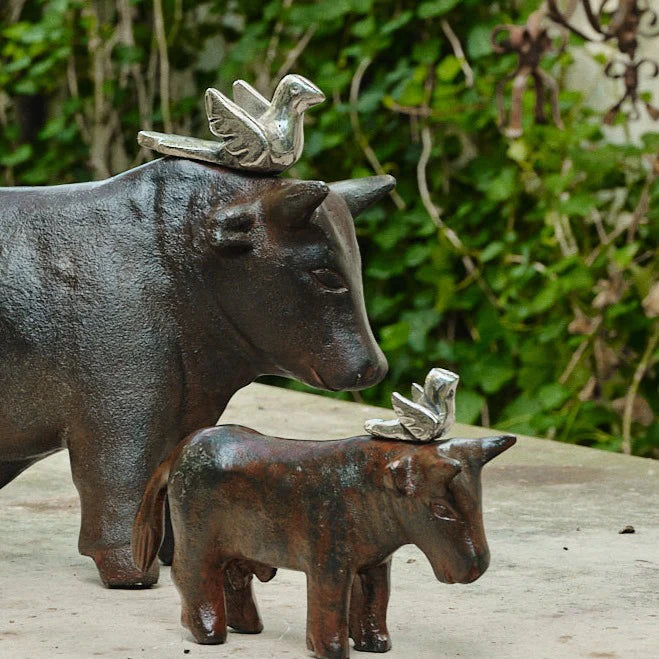 Small sculpture of donkey with bird on the top of its head