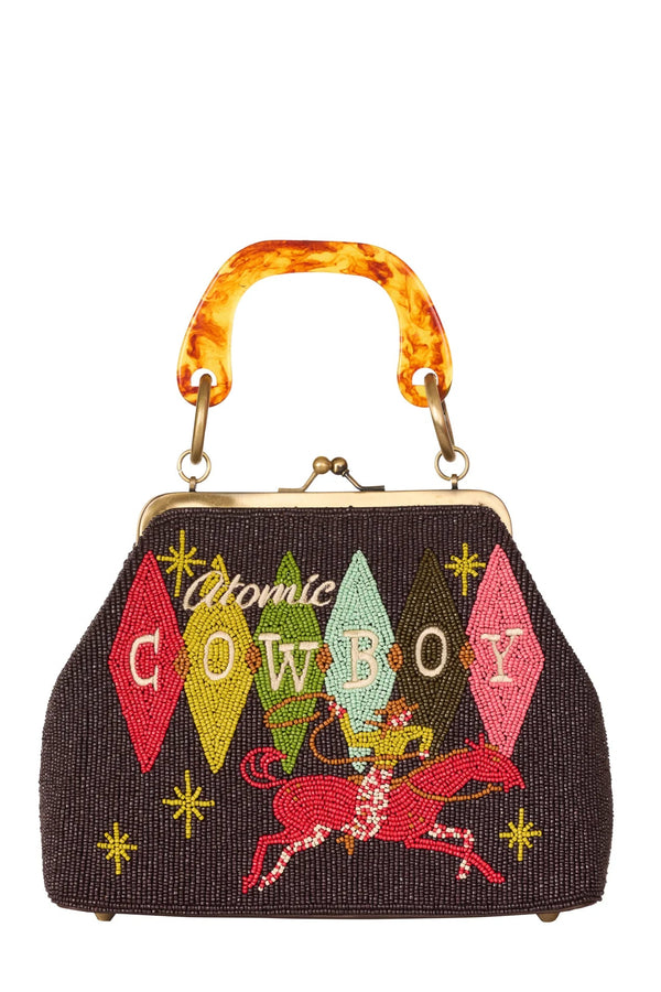 Handbag with 'Atomic Cowboy' design and colorful handle on a white background