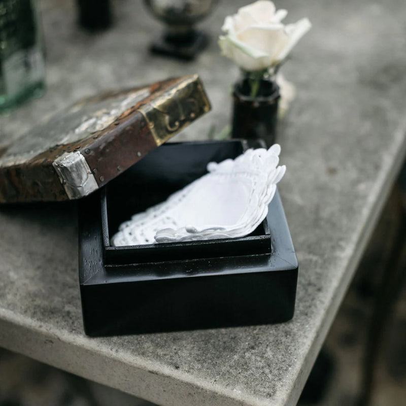 A box with a lid comprised of a mixture of metals and a human heart image displayed on the top