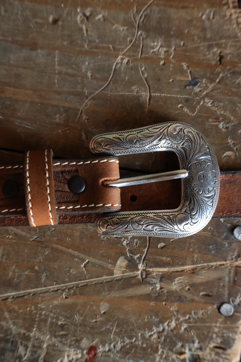 Brown tooled leather belt with silver conchos on it