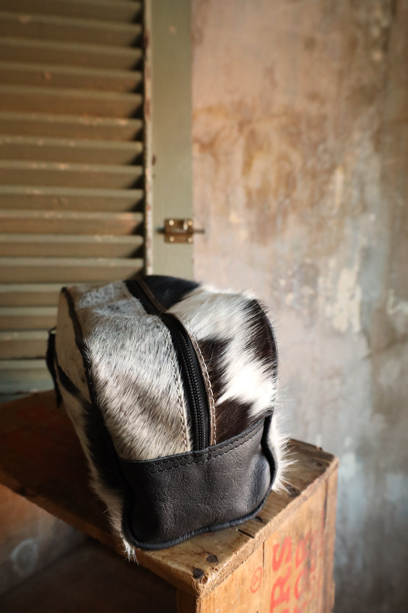Black and white cowhide travel kit with zipper closure for easy travel