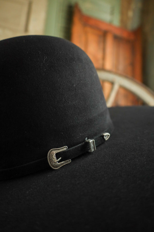 Black hat with a decorative buckle on a blurred background