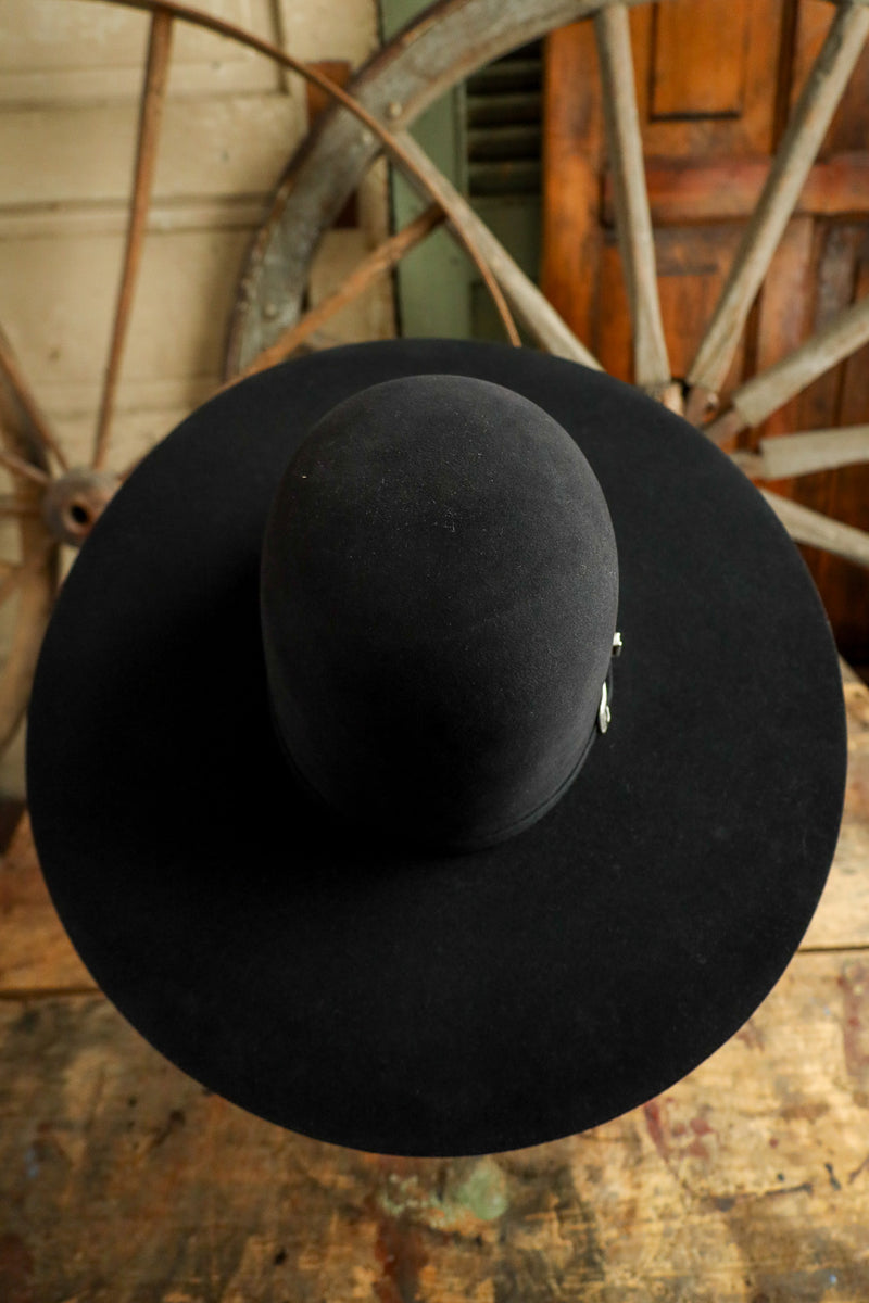 Black hat on a wooden surface with a rustic background