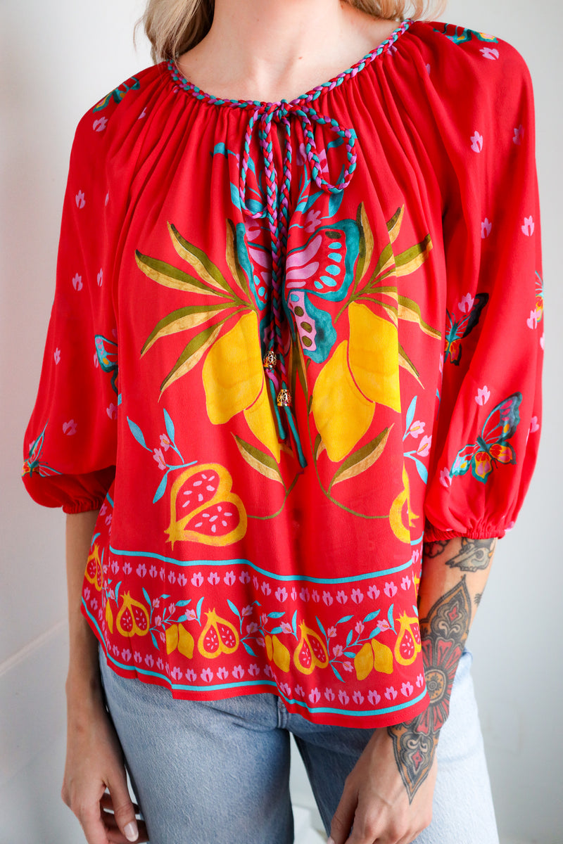 Red blouse with colorful floral pattern worn by a person