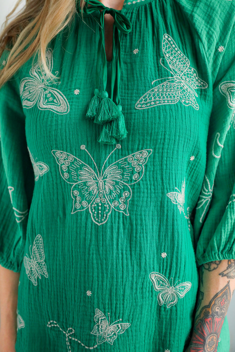 Green shirt with white butterfly patterns worn by a person