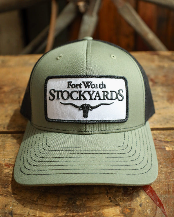 Green cap with Fort Worth Stockyards logo on a wooden surface