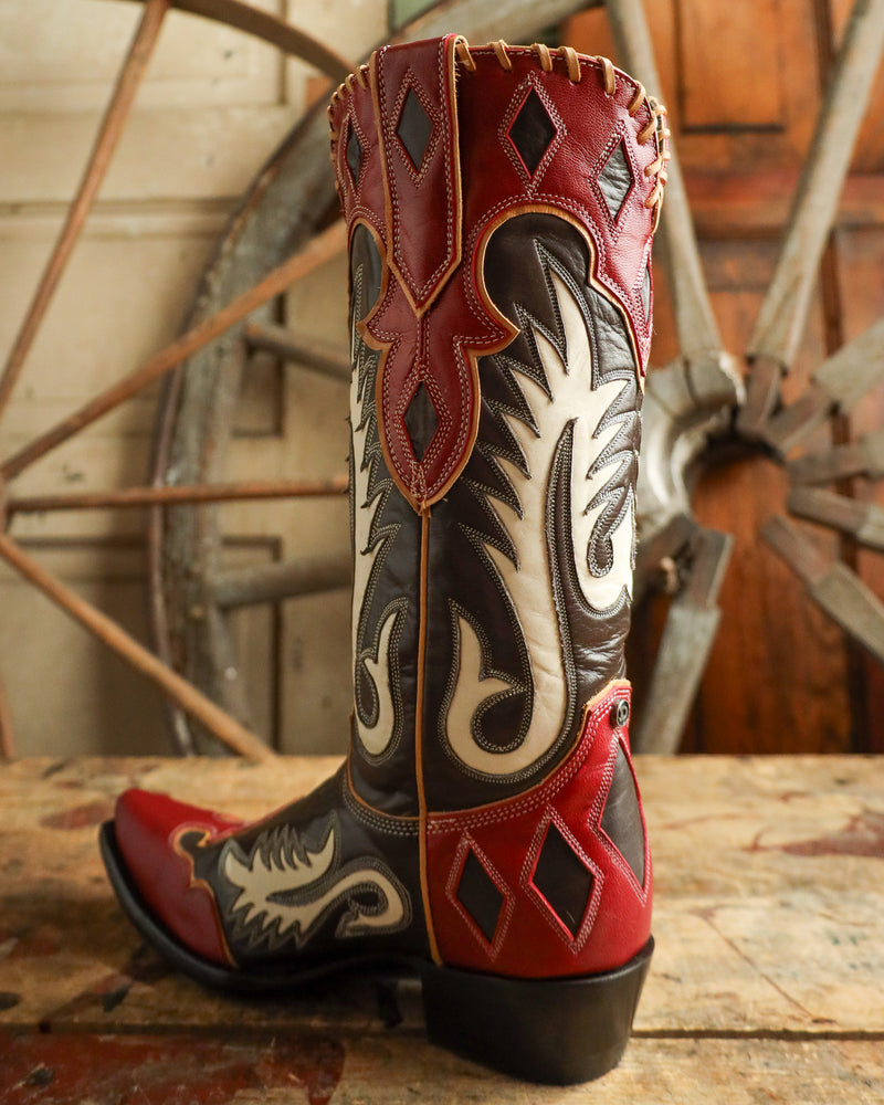 Cowboy boot with intricate design on a wooden surface